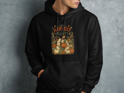 Black hoodie with autumn harvest design featuring a man holding a pumpkin.