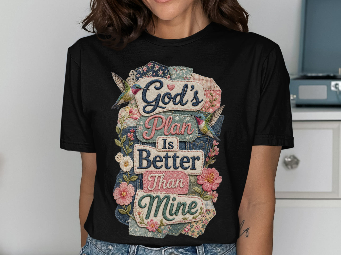 Black t-shirt with "God's Plan Is Better Than Mine" text, floral, and hummingbird accents.