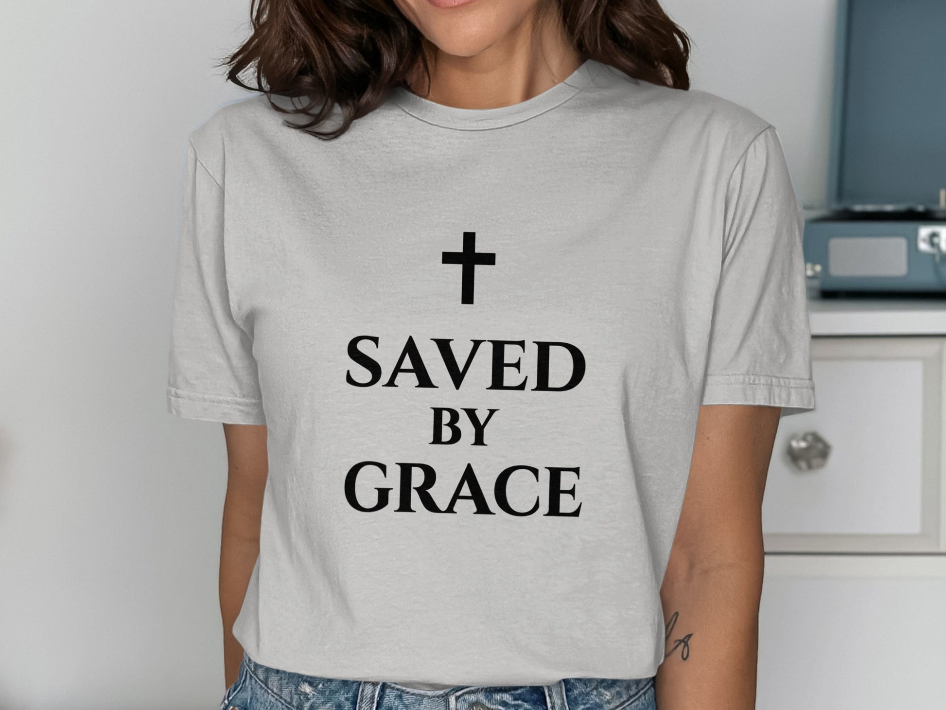 Gray t-shirt with black text: "SAVED BY GRACE" and a cross.