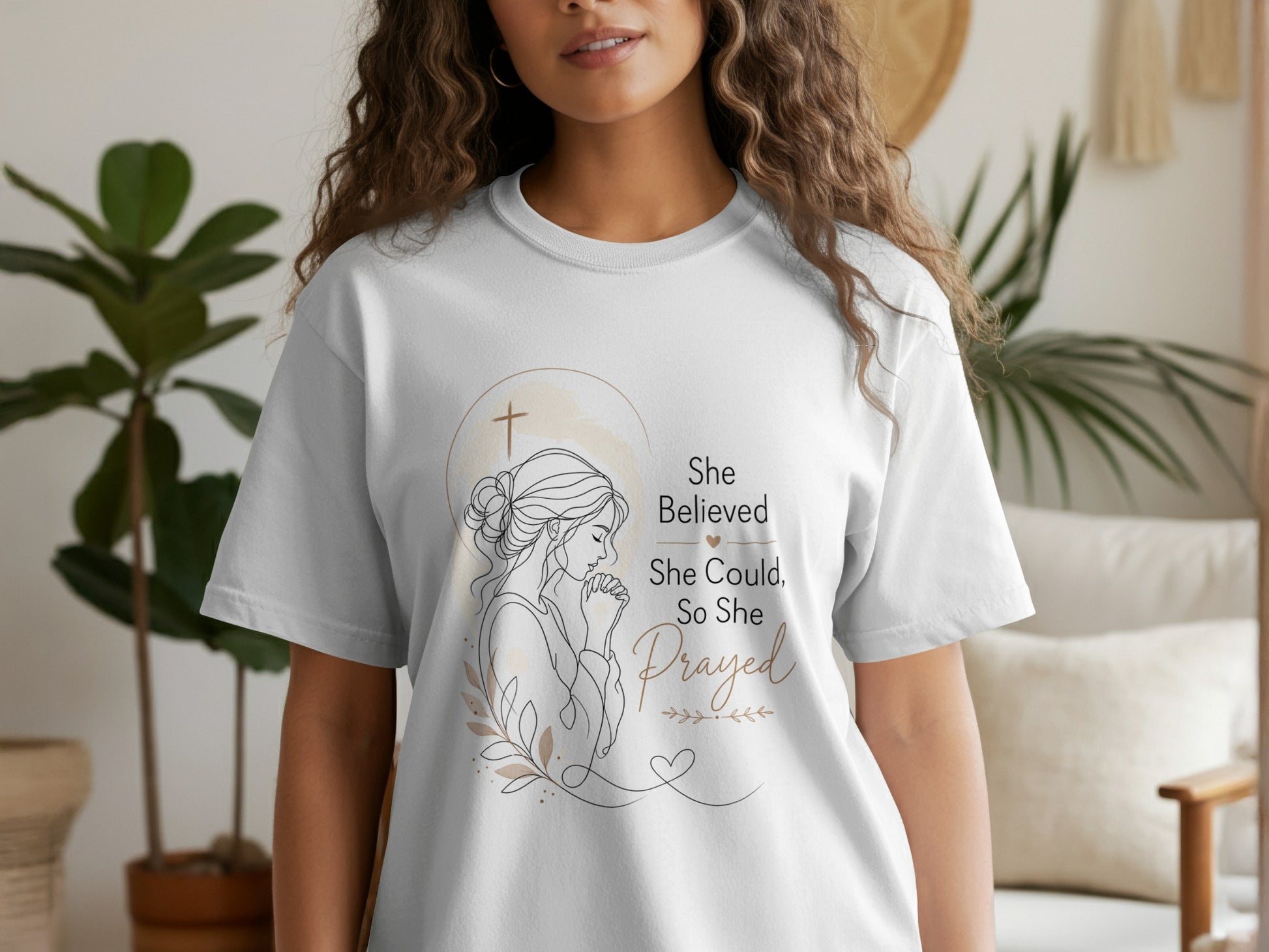 White t-shirt with line art of praying woman and text "She Believed She Could, So She Prayed."