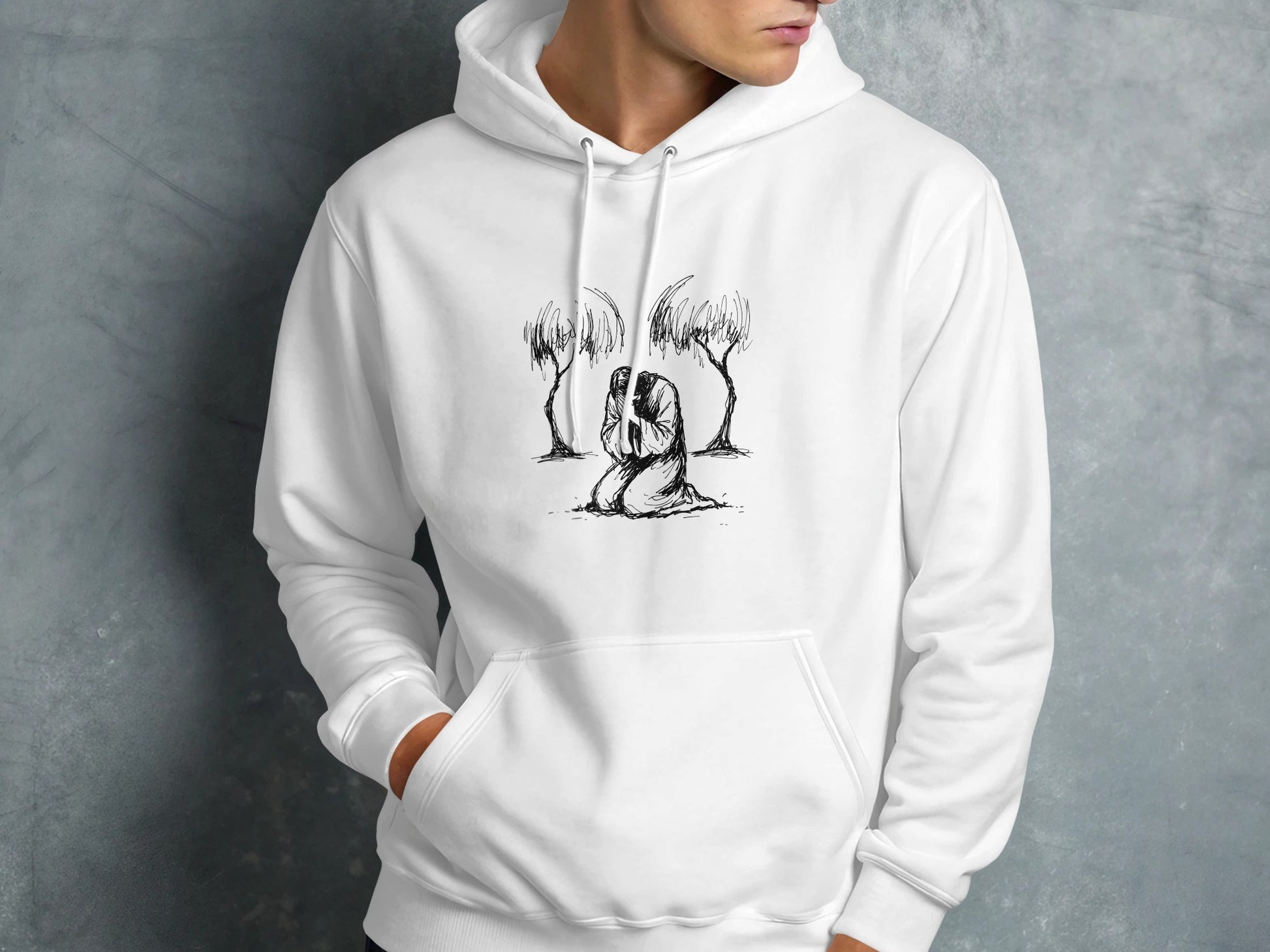 White hoodie with a sketch of a person kneeling between two trees.