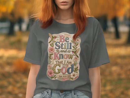Gray t-shirt with floral design and text "Be Still and Know That I Am God".