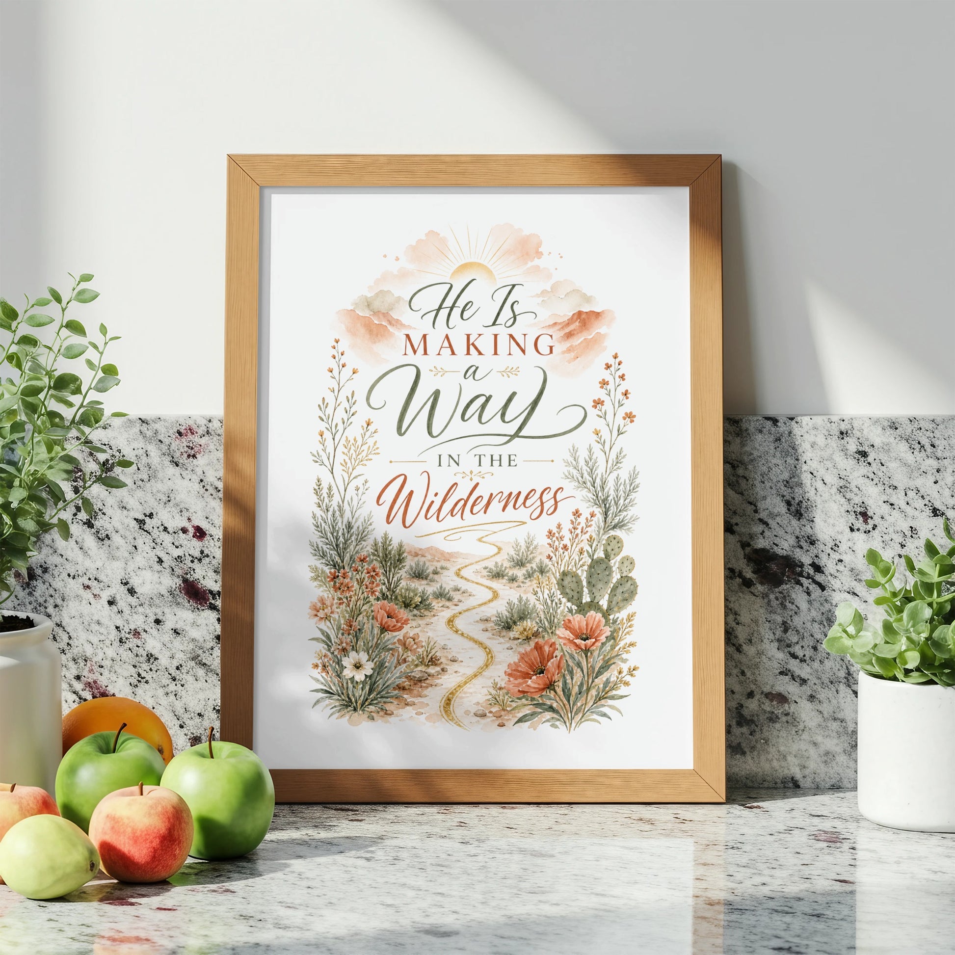 Framed artwork with text "He Is Making a Way In The Wilderness" and floral desert scene.