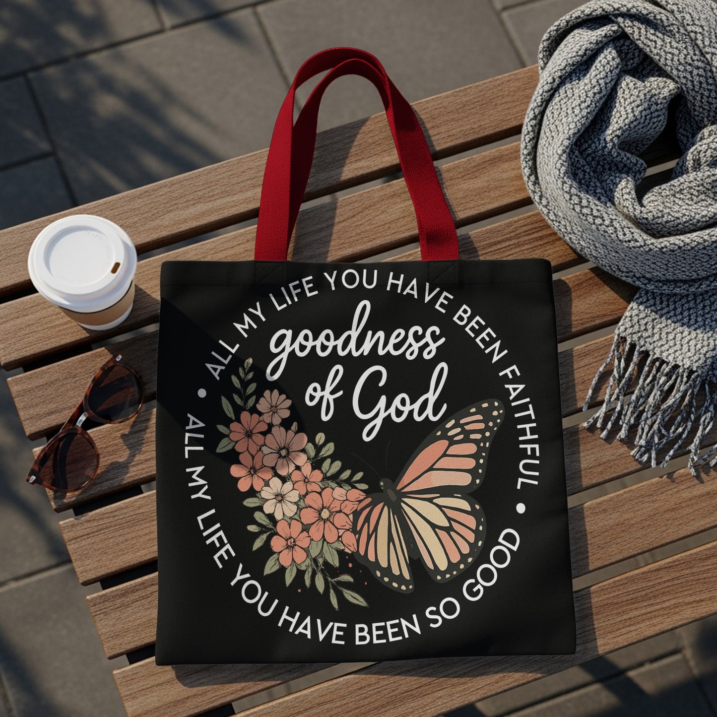 Black tote bag with text "goodness of God" and floral butterfly design.