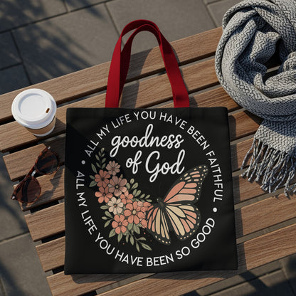 Black tote bag with text "goodness of God" and floral butterfly design.