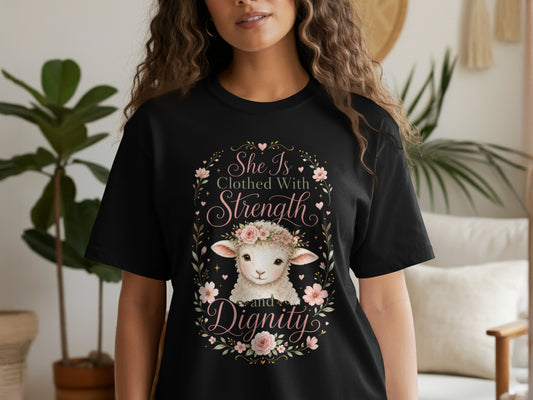 Black t-shirt with a lamb wearing a flower crown and text that reads "She Is Clothed With Strength and Dignity."