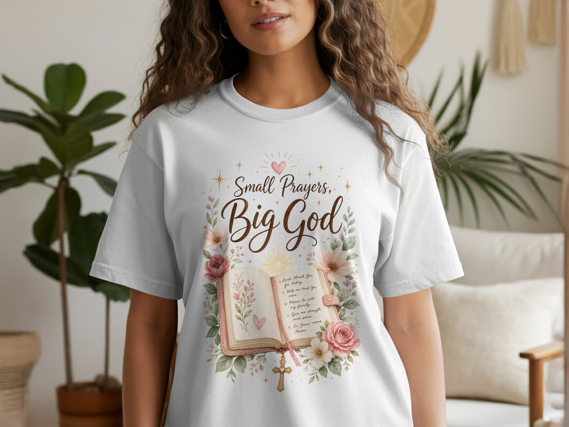 White t-shirt with "Small Prayers, Big God" featuring an open bible, flowers, and a cross.
