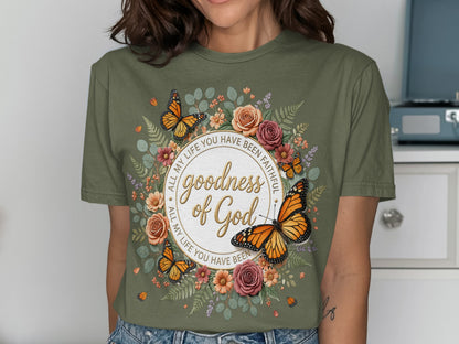 Green t-shirt with butterflies, flowers, and "goodness of God" text.