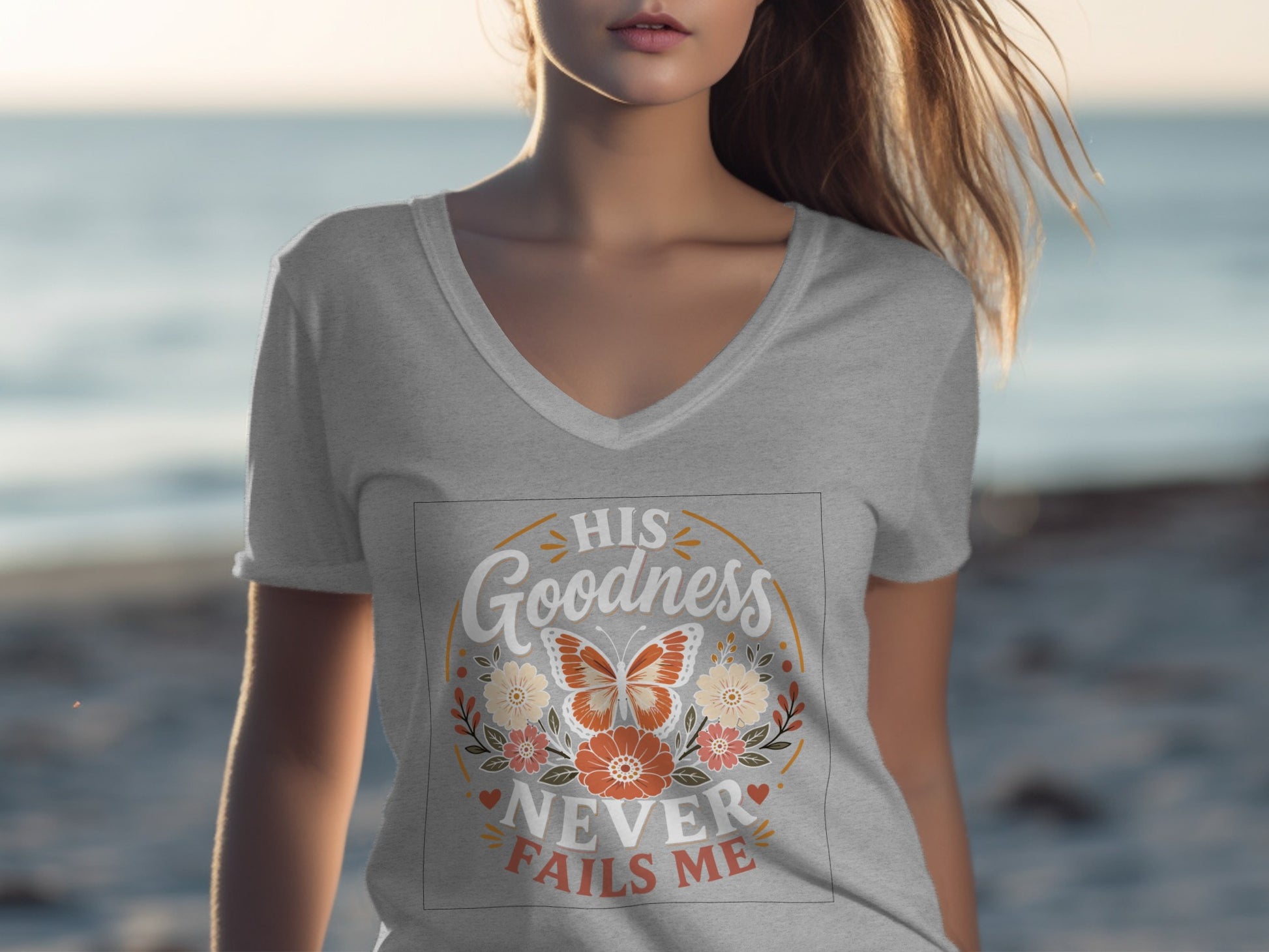 Grey t-shirt with "His Goodness Never Fails Me" and floral butterfly design.