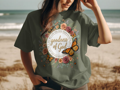 Green t-shirt with floral design, butterfly, and text "goodness of God".