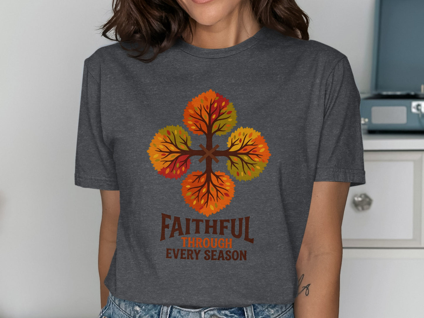 T-shirt with four colorful autumn trees forming a cross, text reads "Faithful Through Every Season."