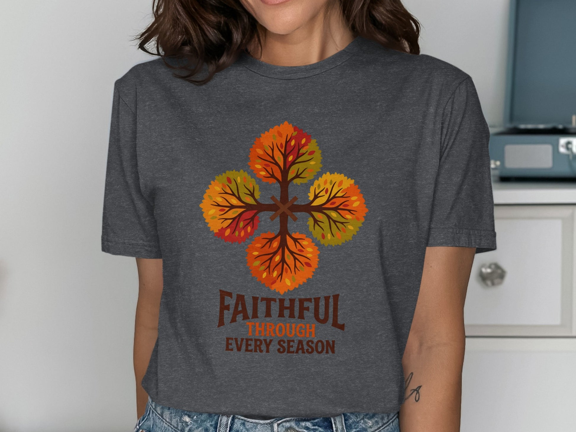 T-shirt with four colorful autumn trees forming a cross, text reads "Faithful Through Every Season."