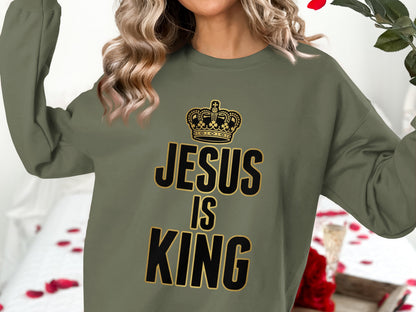 Olive green sweatshirt with "JESUS IS KING" text and crown graphic.