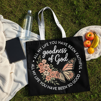 Black tote bag with "goodness of God" and floral butterfly design.