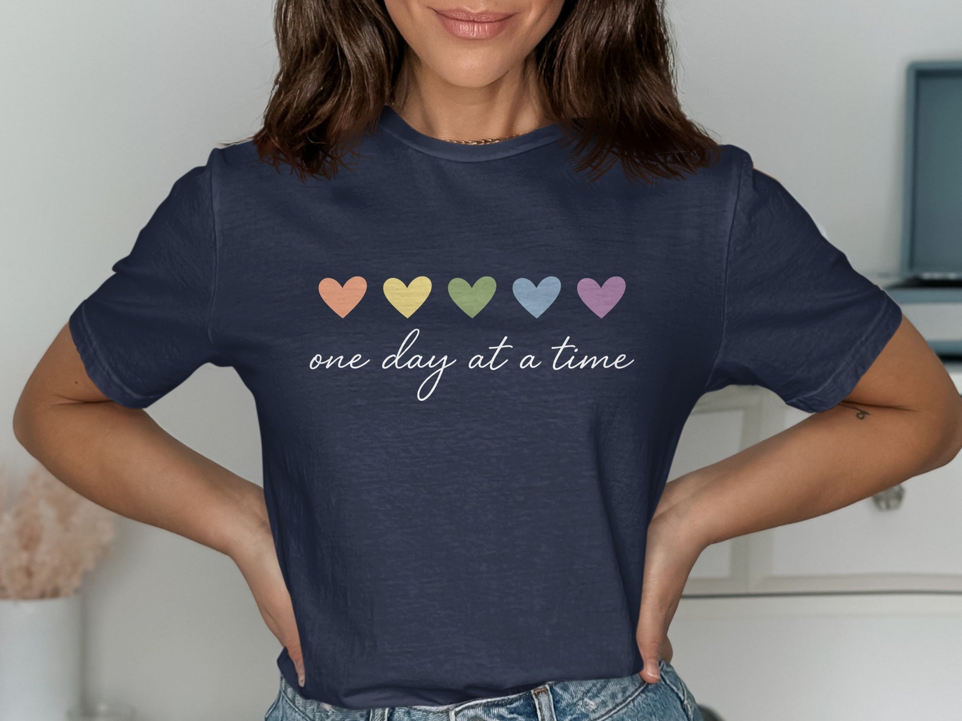 Dark blue t-shirt with pastel hearts and "one day at a time" text.