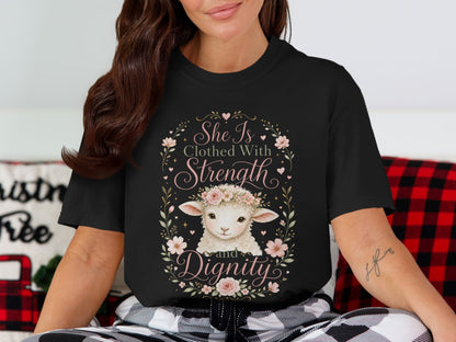 Black t-shirt with a lamb wearing a floral crown and the text "She Is Clothed With Strength and Dignity".