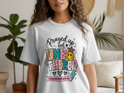 White t-shirt with "Prayed up and Unbothered because God's got it" graphic.