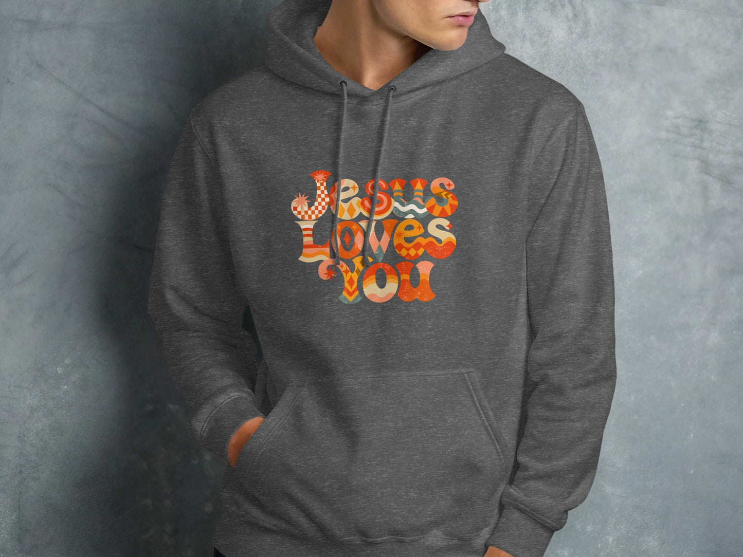 Dark gray hoodie with "Jesus Loves You" graphic in colorful retro font.