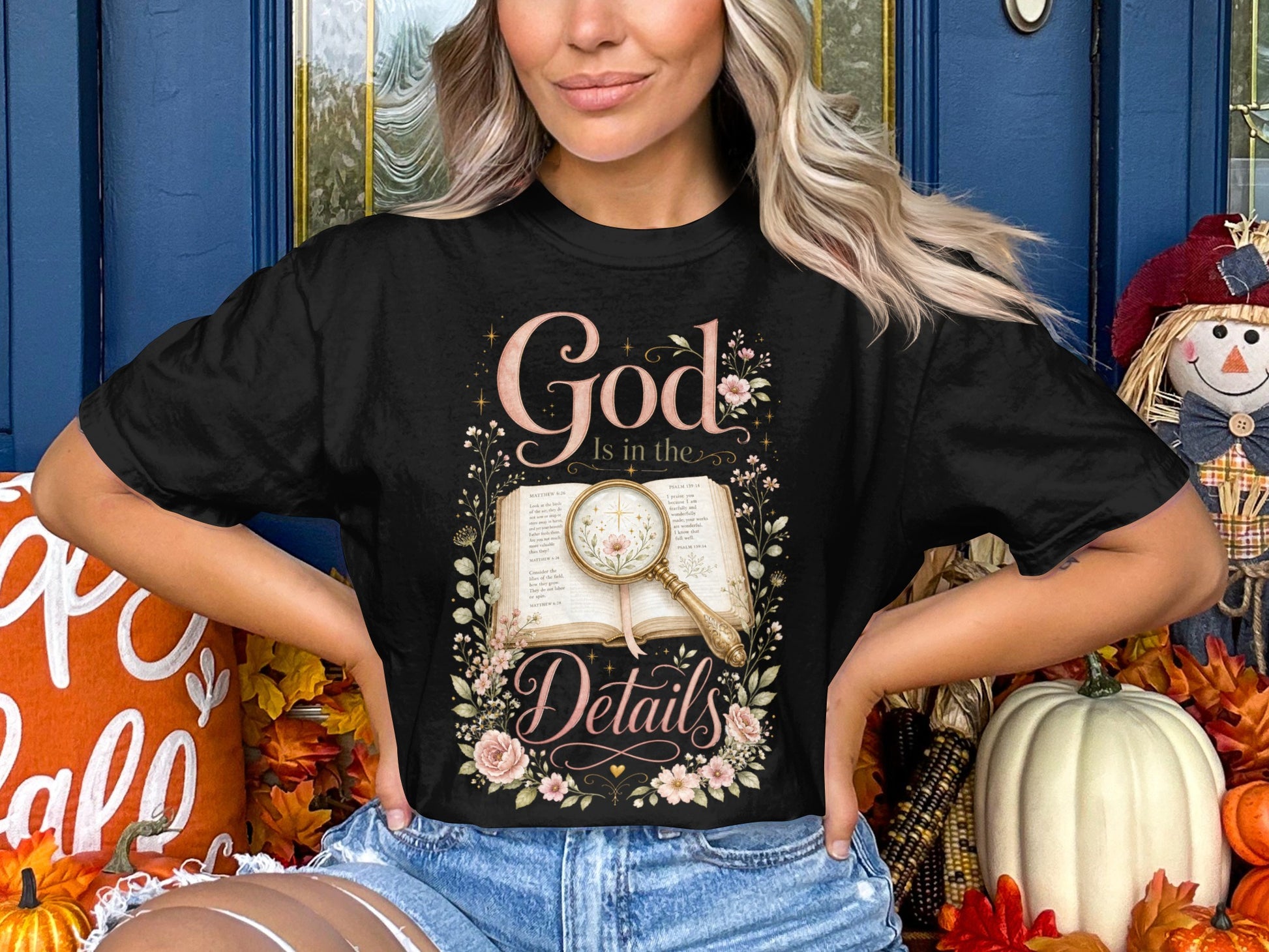 Black t-shirt with "God Is in the Details" biblical text and floral design.