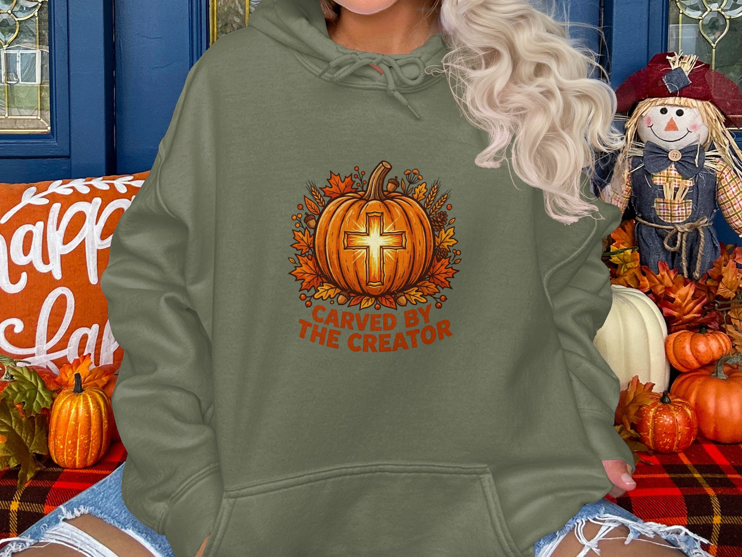 Green hooded sweatshirt with "Carved by the Creator" text and a cross-shaped pumpkin.