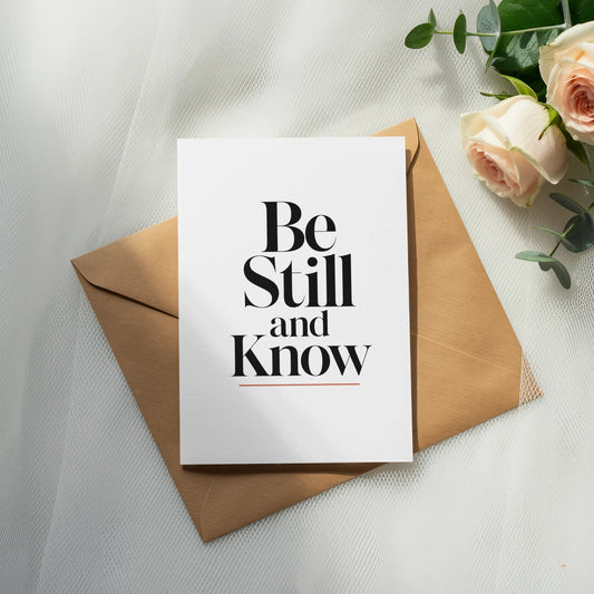 Card with "Be Still and Know" text on a kraft envelope with roses.