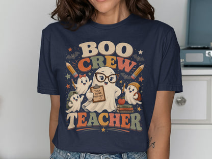 "Boo Crew Teacher" text with ghosts, pencils, bats, and books on a navy t-shirt.