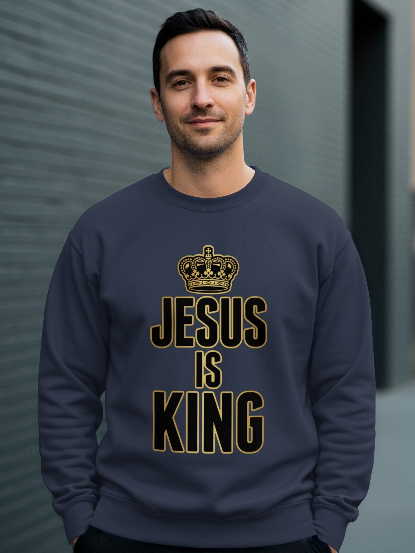 Man wearing a dark blue sweatshirt with "JESUS IS KING" and a crown.