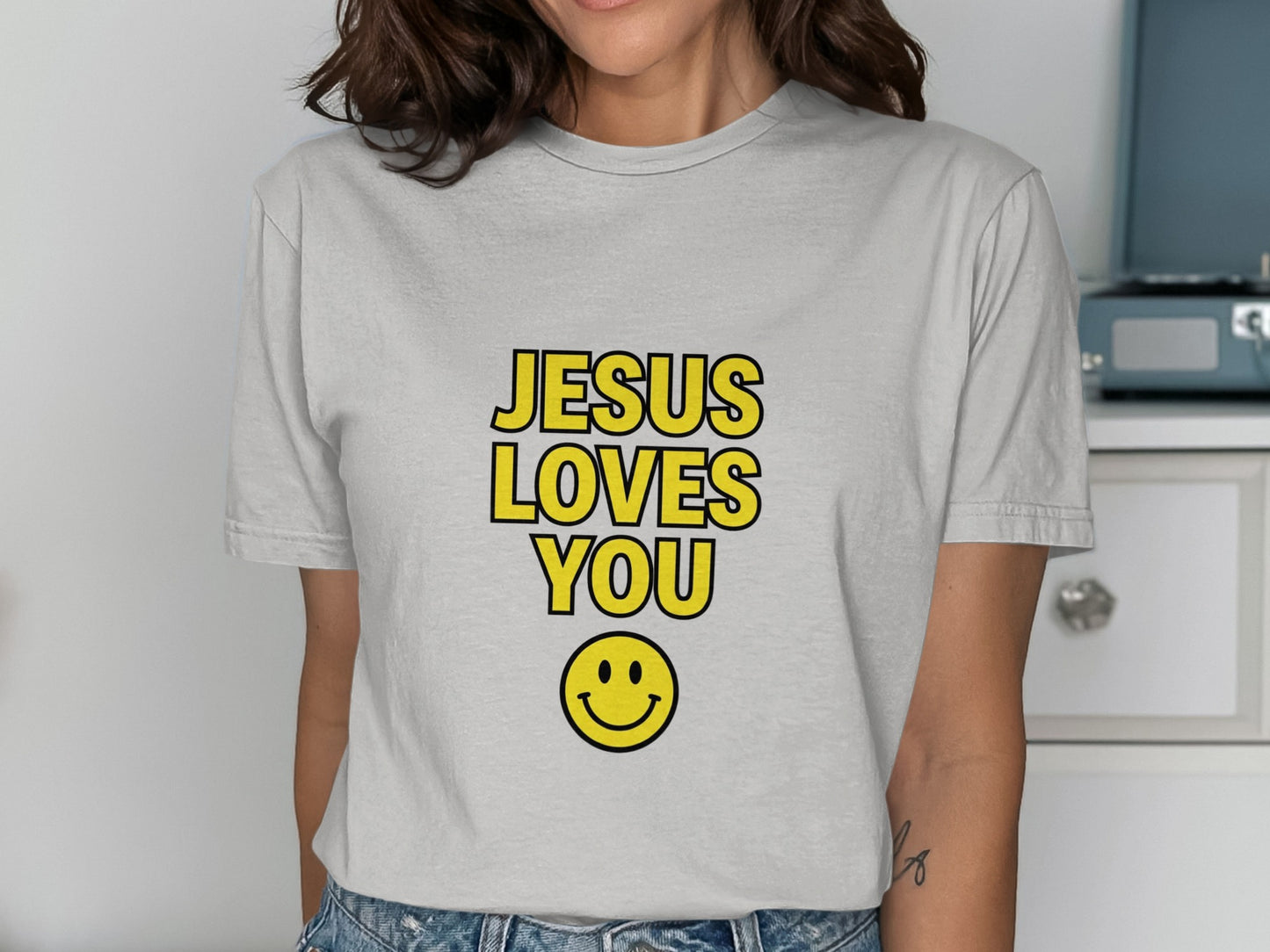 Light gray t-shirt with "JESUS LOVES YOU" and smiley face.