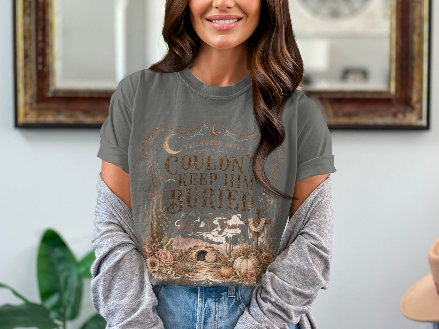 T-shirt with text "Couldn't Keep Him Buried" and Halloween Jesus graphics.