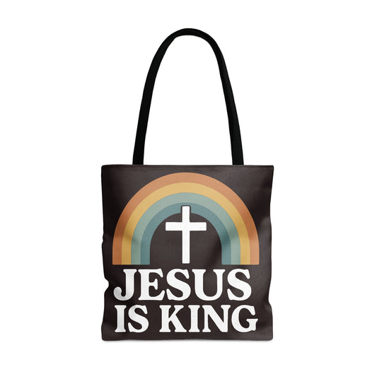 Black tote bag with white text "JESUS IS KING" and a cross inside a rainbow.