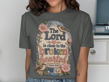 Grey t-shirt with embroidered text "The Lord is close to the brokenhearted Psalm 34:18".