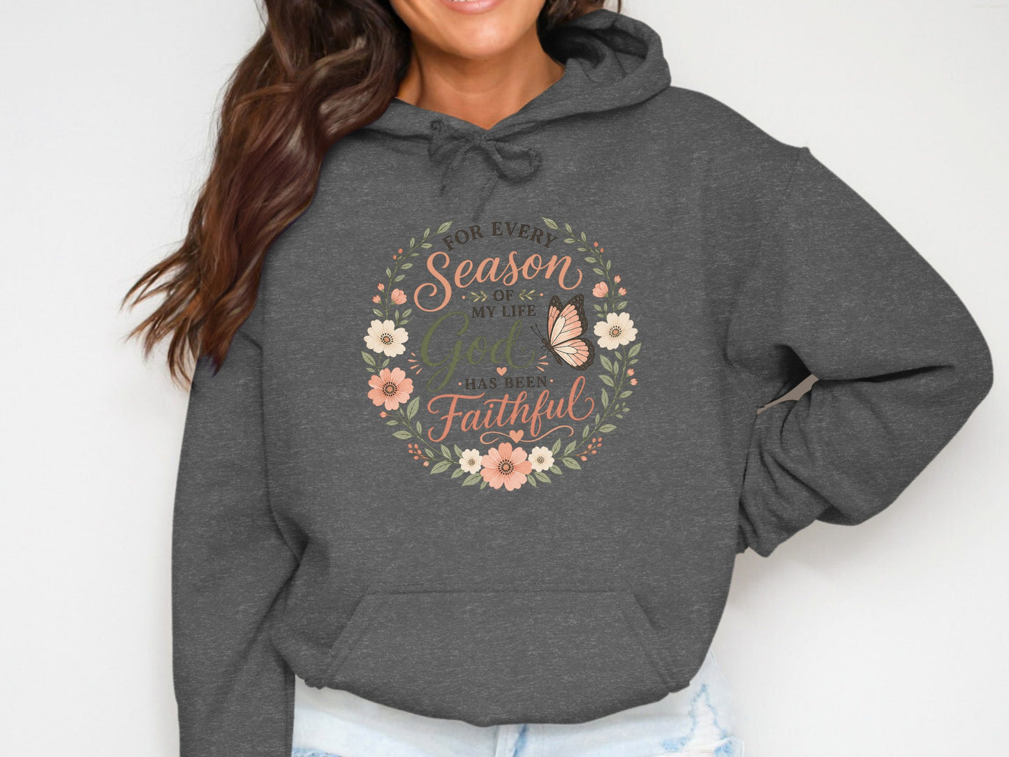 Dark gray hoodie with floral wreath and butterfly reading "For Every Season of My Life God Has Been Faithful".