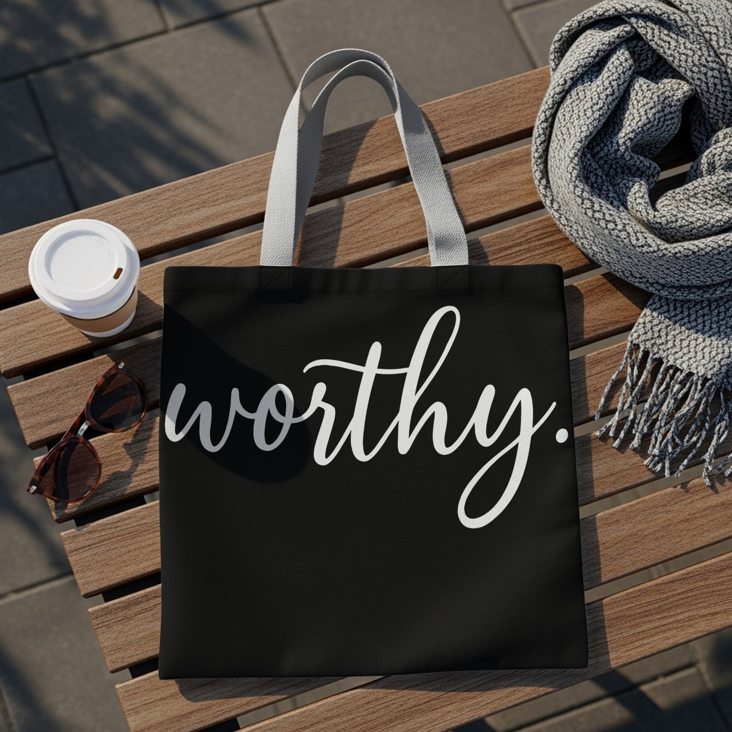 Black tote bag with white cursive text that says "worthy."