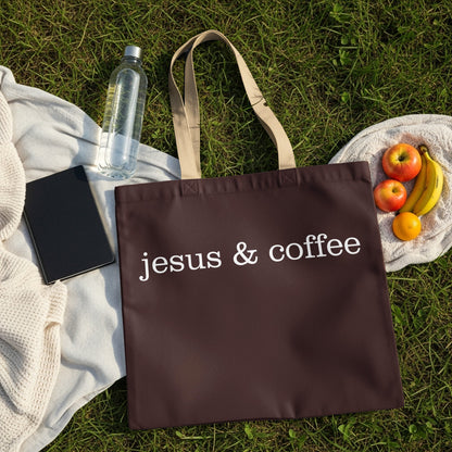 Brown tote bag with white text "jesus & coffee" on grass