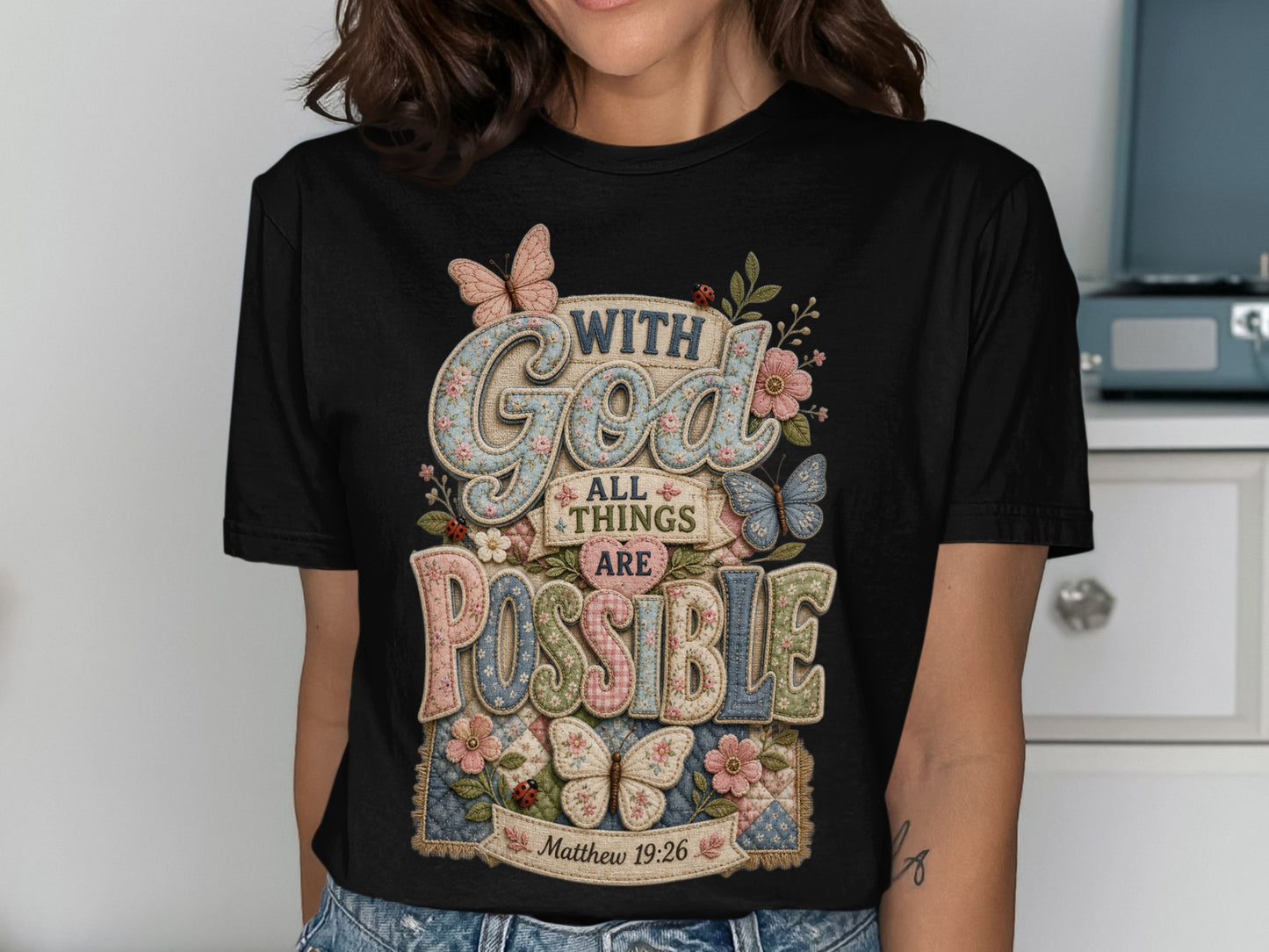 Black t-shirt with "With God all things are possible" text and floral accents.
