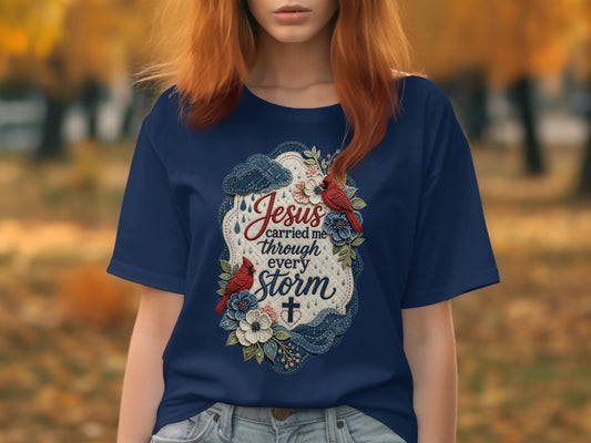 Navy t-shirt with "Jesus carried me through every storm" in script.