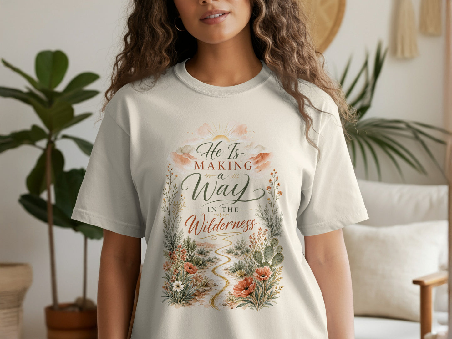 T-shirt with text "He Is Making a Way In The Wilderness" and desert floral design.