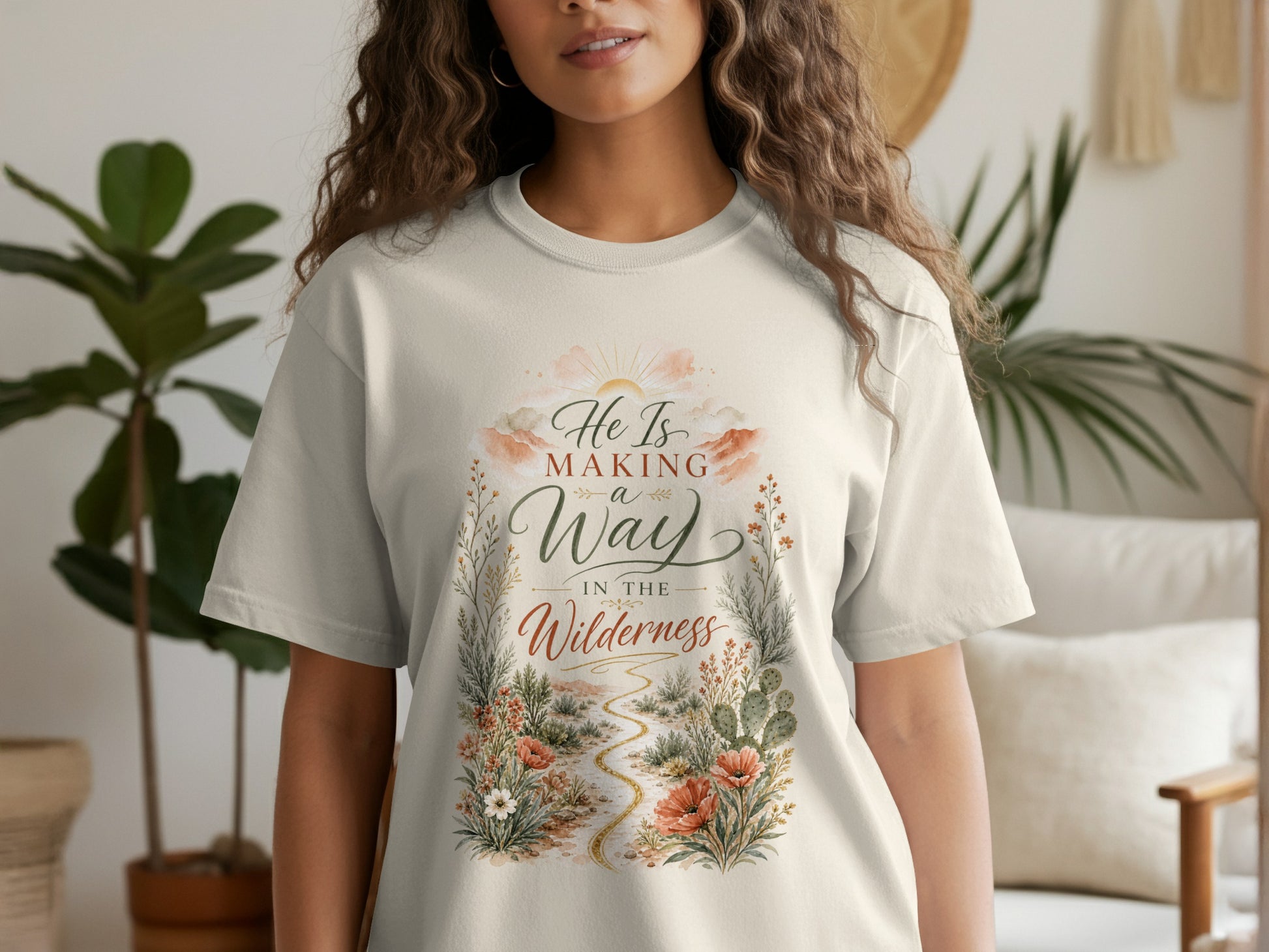 T-shirt with text "He Is Making a Way In The Wilderness" and desert floral design.