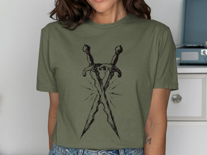 Two crossed daggers with a sketch-like style on an olive green t-shirt.