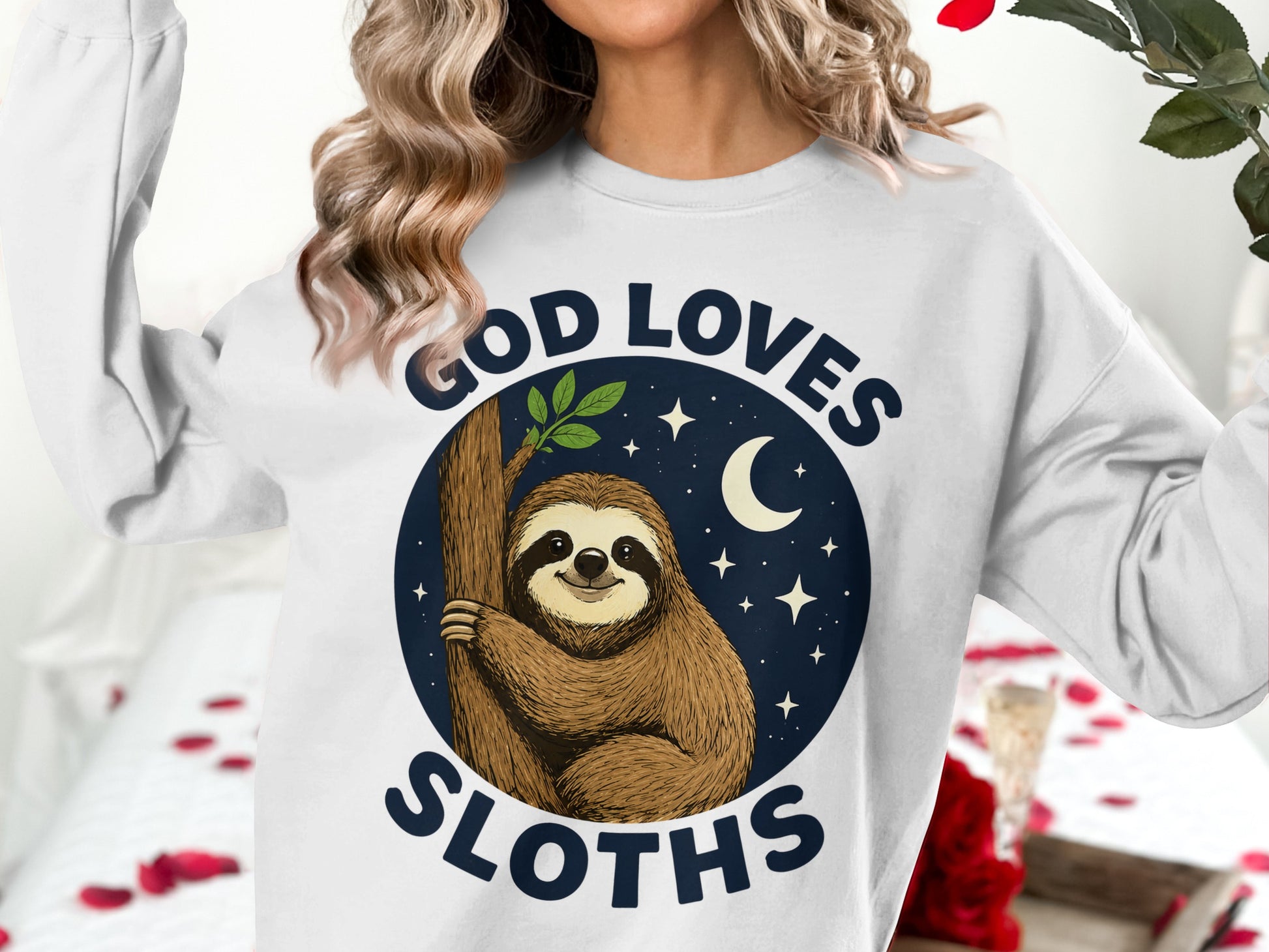 White sweatshirt with a sloth on a tree and "God Loves Sloths" text.