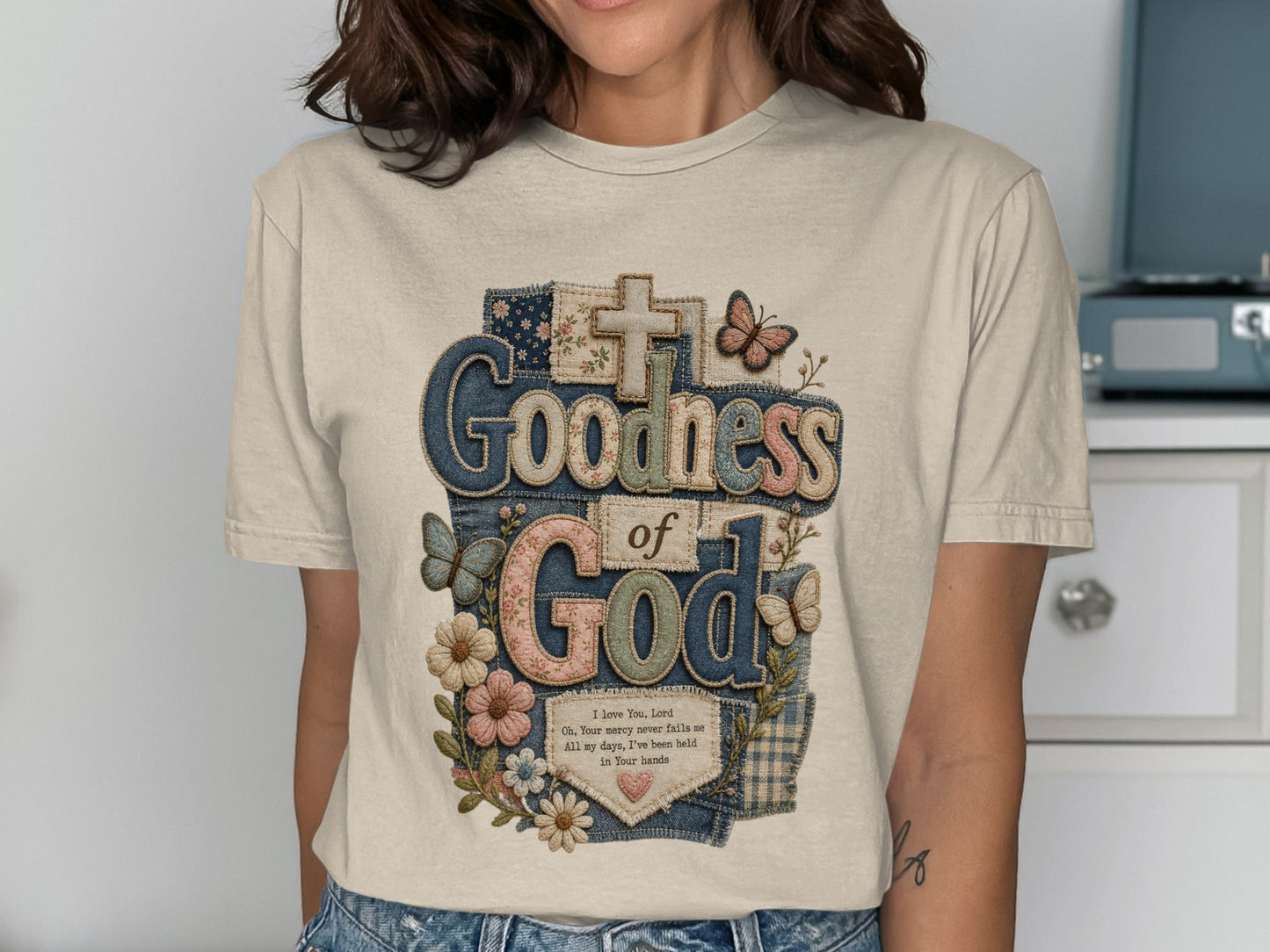 T-shirt with "Goodness of God" text, butterflies, and flowers.