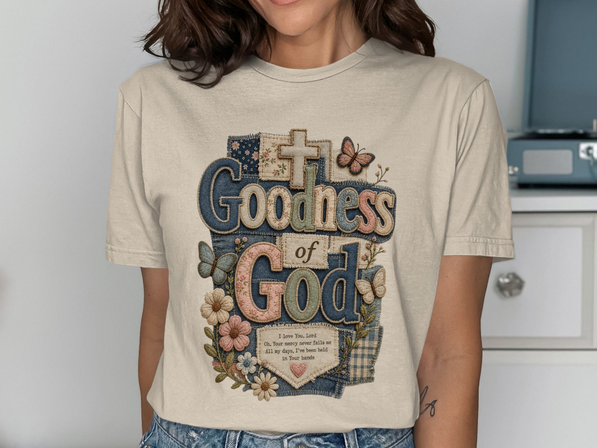 T-shirt with "Goodness of God" text, butterflies, and flowers.
