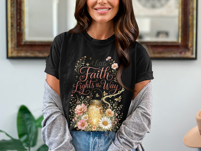 Black t-shirt featuring a mason jar with lights, flowers, and text "A Little Faith Lights the Way."