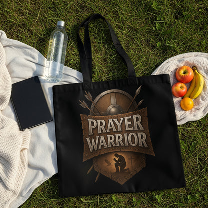 Black tote bag with "Prayer Warrior" text, shield, and praying figure design.