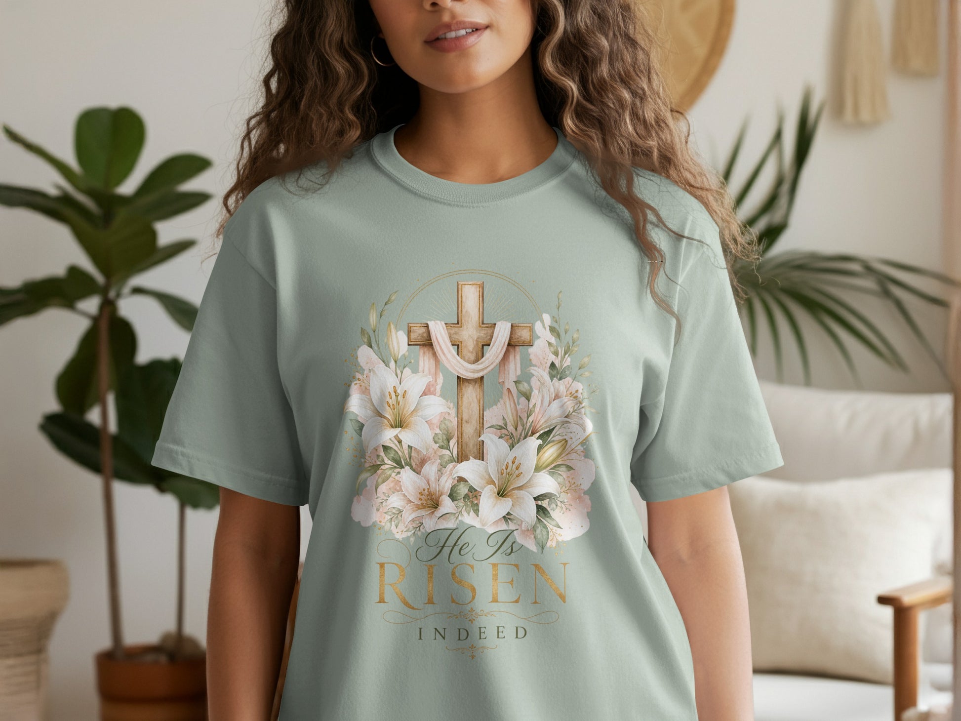 Pale green t-shirt with a wooden cross, draped fabric, lilies, and text "He Is Risen Indeed".