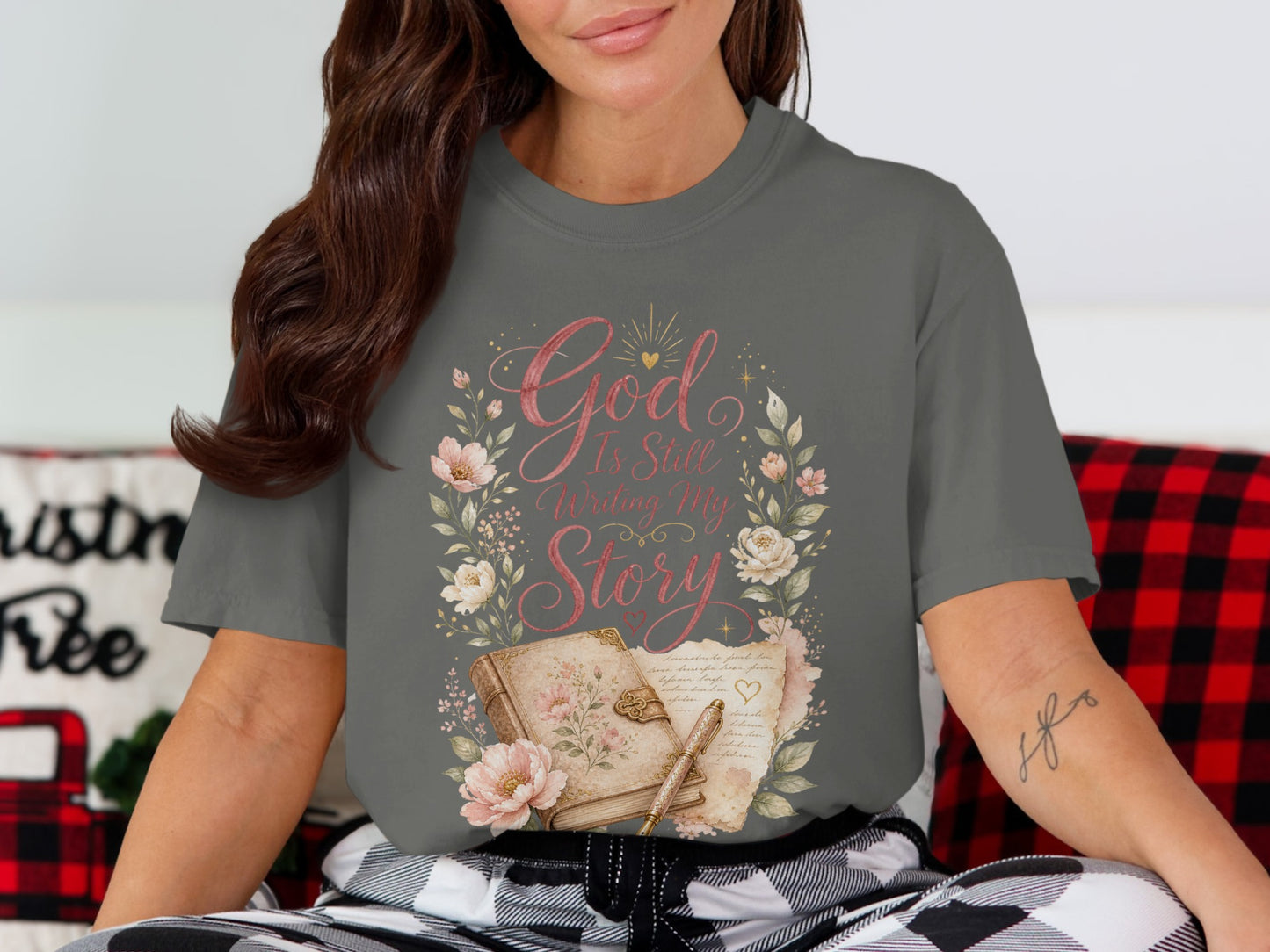 Gray t-shirt with floral wreath, book, pen, and text "God Is Still Writing My Story".