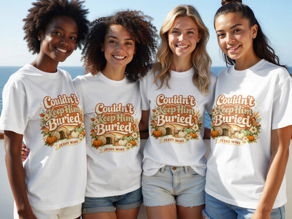 Four women model white t-shirts with text "Couldn't Keep Him Buried JESUS WINS".