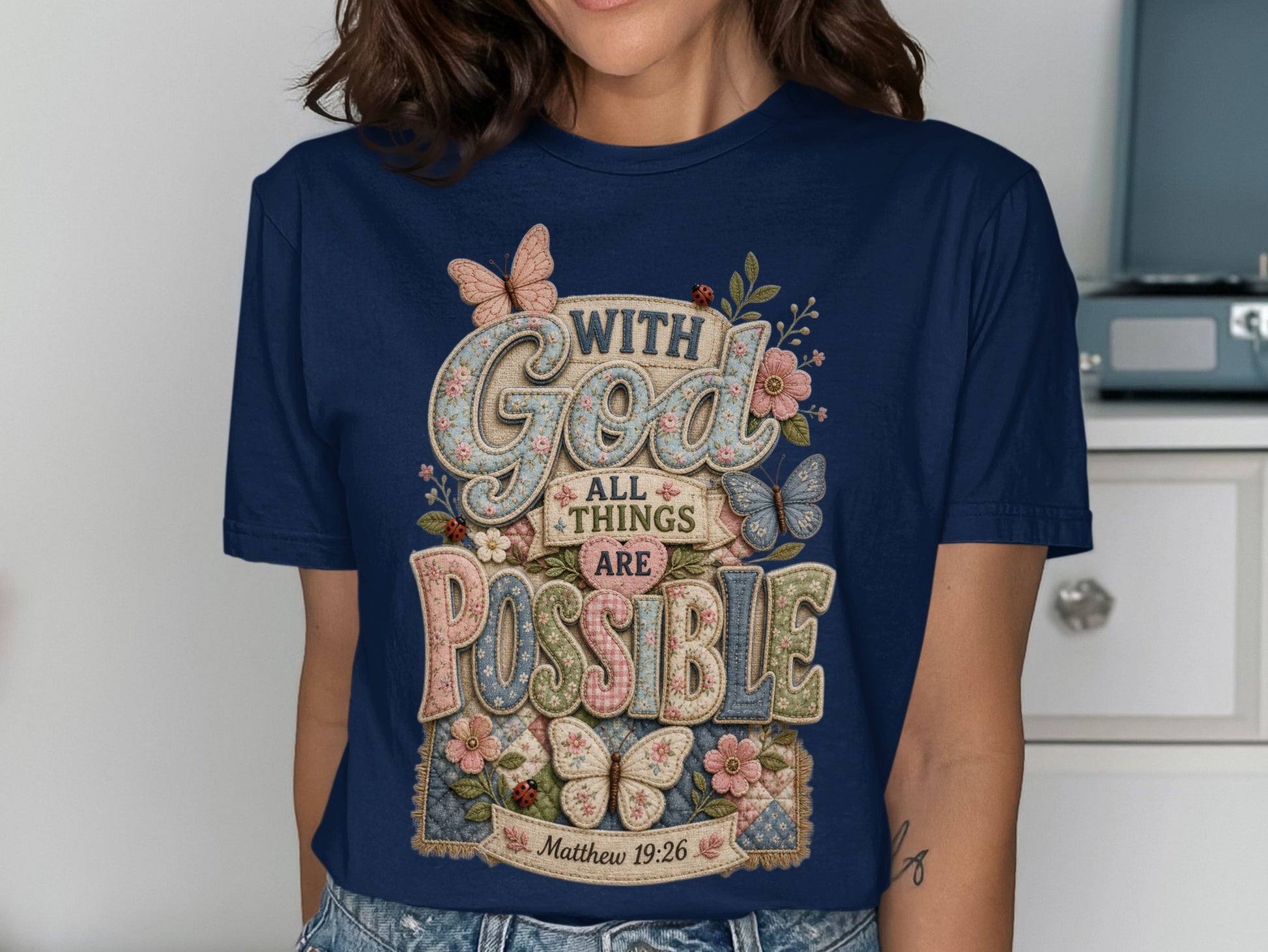 Navy t-shirt with "God all things are possible" text and floral, butterfly, ladybug motifs.