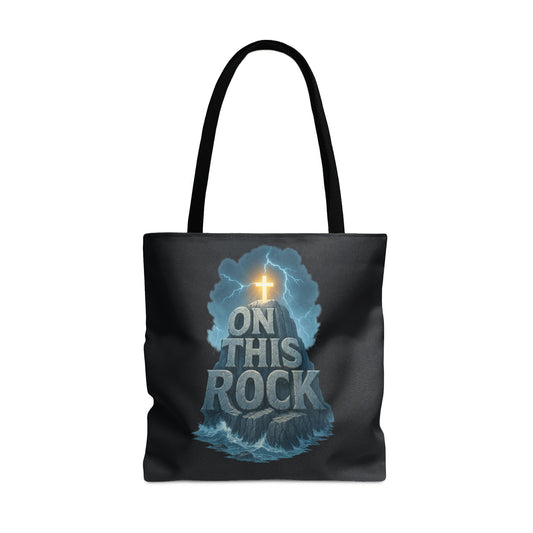 Black tote bag with the phrase "ON THIS ROCK" over a rock formation and cross.