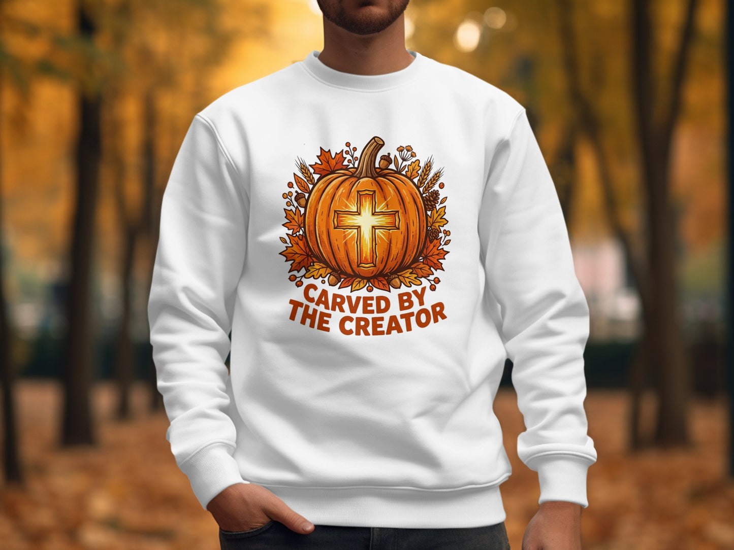 White sweatshirt with a pumpkin, cross, and autumn leaves design.